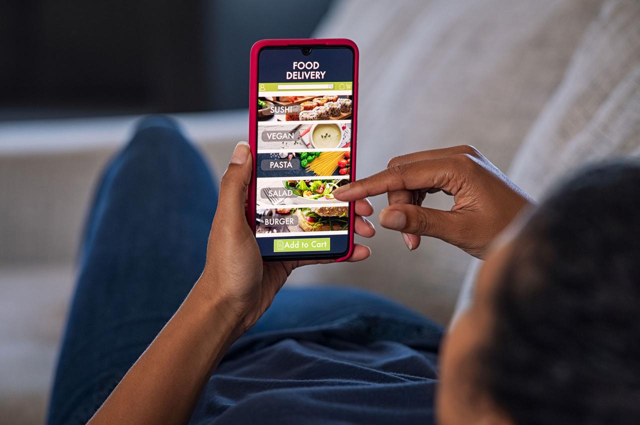 A woman uses a food delivery app on her phone